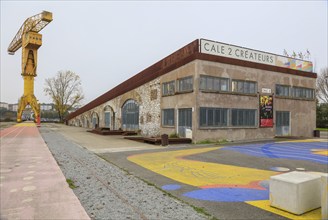 Yellow crane and dry dock, former shipyard of the Chantiers d'Atlantique on the Ile de Nantes in