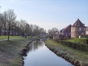 A quiet canal with brick buildings and trees along the banks, coesfeld, münsterland, germany