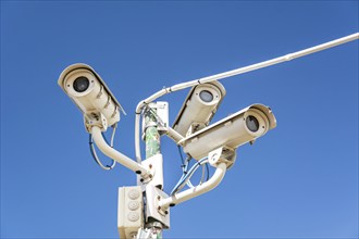 Surveillance cameras in front of blue sky