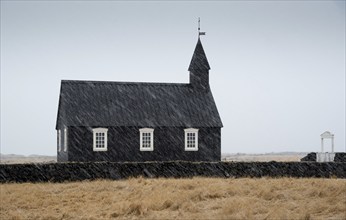 Famous picturesque black church of Budir at Snaefellsnes peninsula region in Iceland during a heavy