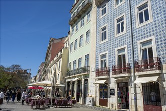 House facades in Lisbon, street scene with buildings and cafés decorated with blue tiles,