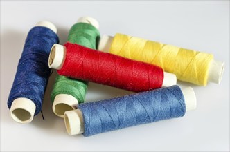 Colorful spools of yarn on white background