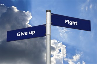 Street sign in front of dark clouds symbolizing choice between 'give up' and 'fight'