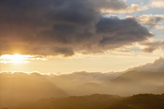 Mist in the mountains in autumn. The evening sun lights up the valleys. France Europe, Vosges