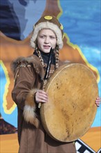 Girl dancing with tambourine in tradition clothing aboriginal people Kamchatka Peninsula. Concert,