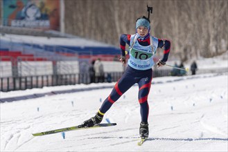 Sportsman biathlete Solodikov Ivan skiing on ski track distance biathlon arena during Junior