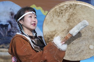 Woman dancing with tambourine in tradition clothing aborigine people Kamchatka. Concert,