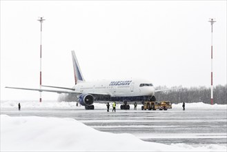 PETROPAVLOVSK-KAMCHATSKY, KAMCHATKA, RUSSIA, MARCH 19, 2015: Airdrome trucks pulling airplane