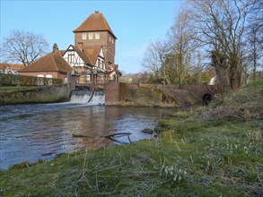 Brick building on the bank of a river with a small weir, coesfeld, münsterland, germany