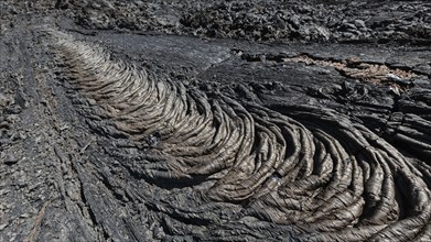 Lava field volcano landscape of Kamchatka Peninsula: view of smooth, undulating surface of black