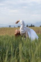 Young dancer woman dancing outdoors. Modern dance performance in the meadow field. Carefree and