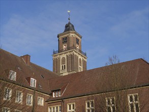 Historic brick building with the imposing church tower under a blue sky, coesfeld, münsterland,