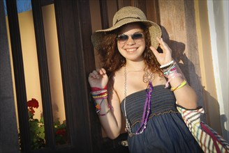 Caucasian happy woman with a sun hat smiling in Oia, Santorini Greece. Summer vacations in Greek