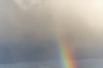 Rainbow appearing in rainy clouds in spring. Bas Rhin, Alsace, France, Europe