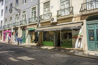 Grocery shop in Lisbon, Lively shopping street with historic buildings and shops in daylight,