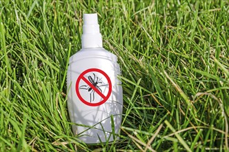 Insect repellent spray lying in the grass