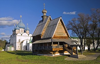 The wooden church on the background of the cathedral of Suzdal's Kremlin