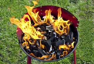 Flames and coal on a barbecue grill in summer