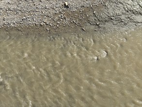 Muddy water is flowing in the arda river near mignano val tolla, piacenza, italy, creating a