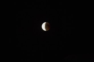 During a lunar eclipse, part of the moon darkens at night