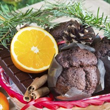 Christmas holiday still life with close up muffins, cinnamon sticks, oranges, chocolate and pine