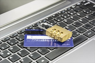 Credit card and padlock on computer keyboard symbolizing secure online payments