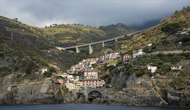 Village of Riomaggiore at the edge of a rocky cliff, Cinque Terre Liguria, Italy, Europe