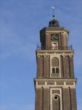 A brick tower with clock in front of a clear blue sky, coesfeld, münsterland, germany