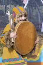 Female child dancing with tambourine in national clothing indigenous inhabitants Kamchatka.