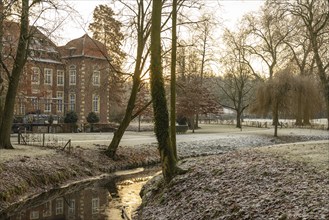 Winter river landscape at sunset with historic building, Velen, North Rhine-Westphalia, Germany,