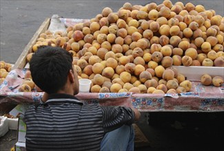 Unrecognized person selling fruits on a food market outdoor. People working in the street