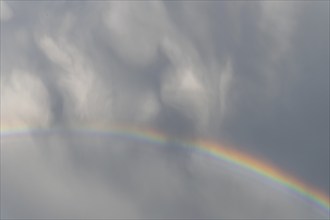 Rainbow appearing in rainy clouds in spring. Bas Rhin, Alsace, France, Europe