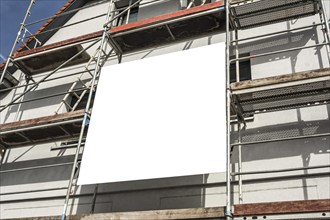 Blank sign on scaffolding at a construction site