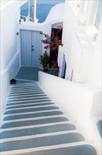 Traditional narrow stair street leading to the sea. Oia village, in Santorini Island, Greece.