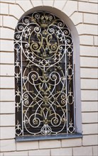 Decorative forged metal window bars in the old building