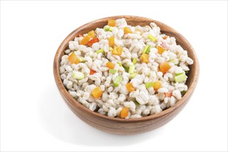 Pearl barley porridge with vegetables in wooden bowl isolated on white background. Side view, close