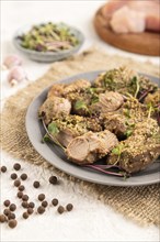 Stewed turkey fillet with garlic and sprouts of radish on white wooden background and linen textile