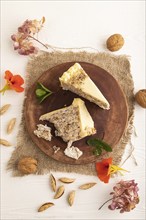 Walnut and almond cake on white wooden background and linen textile. top view, flat lay, close up