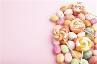 Various caramel candies on pink pastel background. copy space, side view