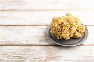 Raw Sparassis (Cauliflower Mushroom) on white wooden background. Side view, copy space