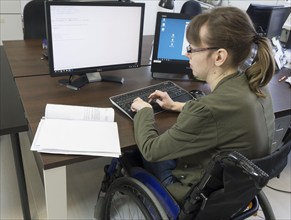 Young woman in a wheelchair at her workplace, Berlin, 18/01/2017