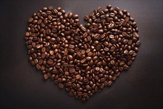 A heart shape formed by roasted coffee beans against a dark background, symbolizing love for