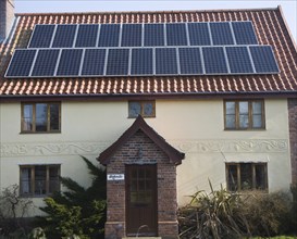 Solar panels on roof of old cottage, Yoxford, Suffolk, England, United Kingdom, Europe