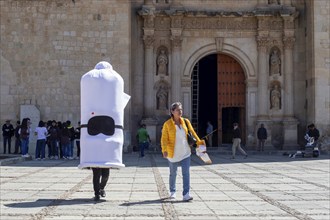 Oaxaca, Mexico, A person wearing a condom costume walks with a health worker handing out free