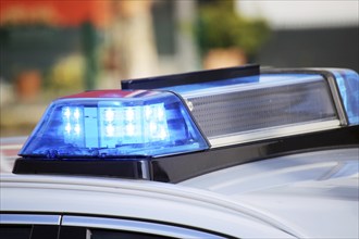 Symbolic image: Close-up of a police car with flashing blue lights