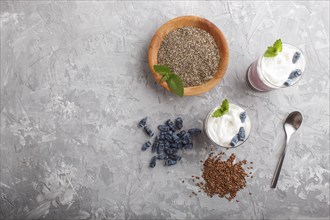 Smoothie with honeysuckle, linen and chia in a glass on gray concrete background. top view, flat