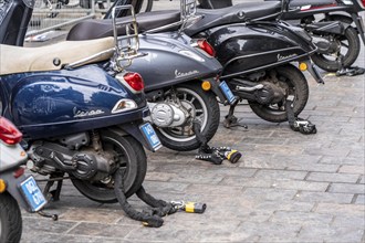 Scooter, locked with thick steel chains, car park in the city centre of The Hague, Netherlands