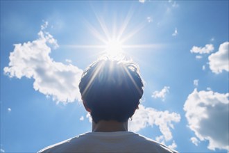 Back view of man looking into sun in blue sky. Generative Ai, AI generated