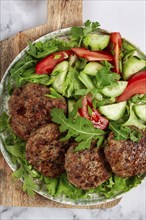 Fried cutlets, mixed minced meat, with vegetable salad, homemade, top view, no people