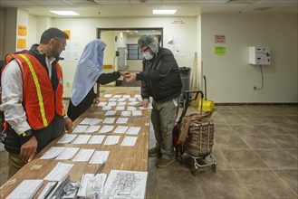 Hamtramck, Michigan USA, 5 November 2024, Election workers check in a man wanting to vote in the